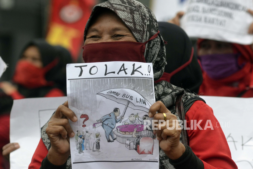 Sejumlah buruh perempuan melakukan aksi damai menolak Undang-Undang Cipta Kerja (Omnibus Law) di Tugu Adipura, Bandar Lampung, Lampung. Upah Minimum Provinsi (UMP) Lampung tahun 2022 hanya naik 0,35 persen atau Rp 8.484,61 dari Rp 2.432.001,57. Hal tersebut berdasarkan Surat Keputusan Gubernur Lampung Nomor G/634/V/08/HK/2021 tertanggal 19 November 2021 tentang UMP Lampung 2022.