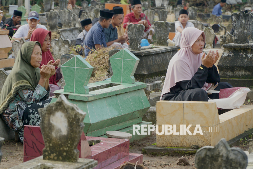 Jamaah doa bersama di pemakaman umum Desa Karanganom, Trenggalek Jawa Timur, Ahad (23/2/2025). Ritual ziarah kubur berjamaah tersebut ditujukan untuk mendoakan arwah leluhur atau anggota keluarga yang sudah meninggal menjelang Bulan Suci Ramadhan. 