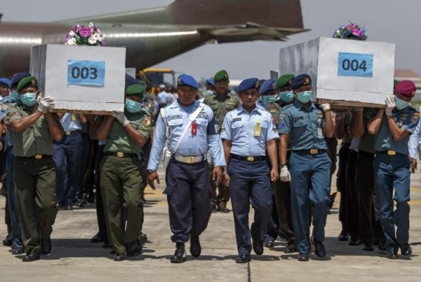Indonesian military personnel carry caskets containing the remains of passengers onboard AirAsia flight QZ8501, recovered off the coast of Borneo, at a military base in Surabaya January 1, 2015.