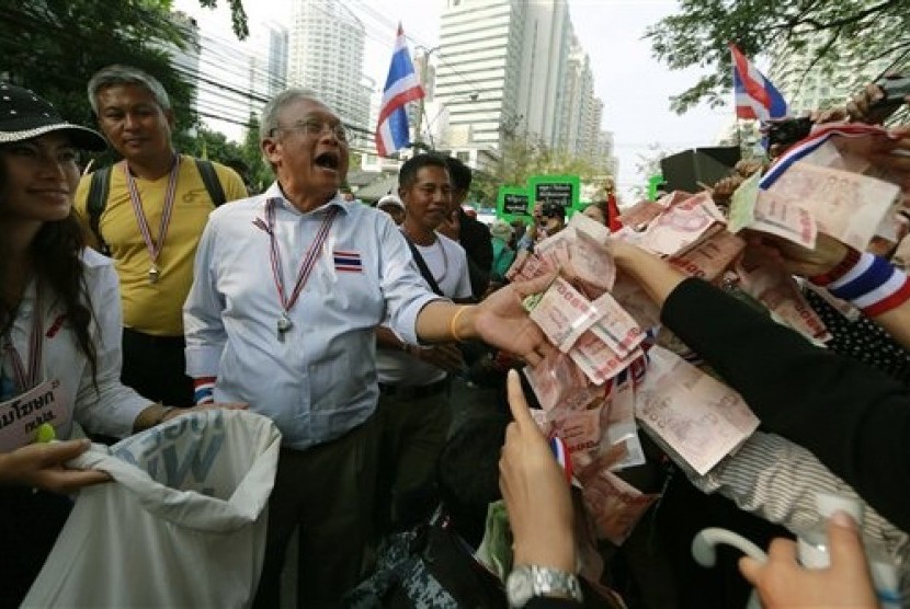  Supporters hand money to Thai anti-government protest leader Suthep Thaugsuban during a march Thursday, Jan. 23, 2014, in Bangkok, Thailand. 