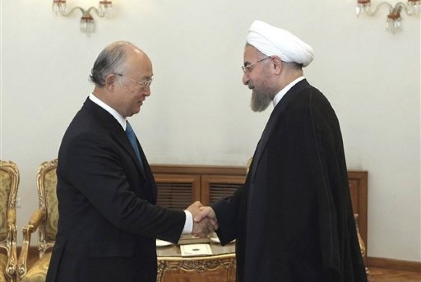 Iran's President Hassan Rouhani (right) shakes hands with Director General of the International Atomic Energy Agency Yukiya Amano at the start of their meeting in Tehran, Iran, Sunday, Aug. 17, 2014. 