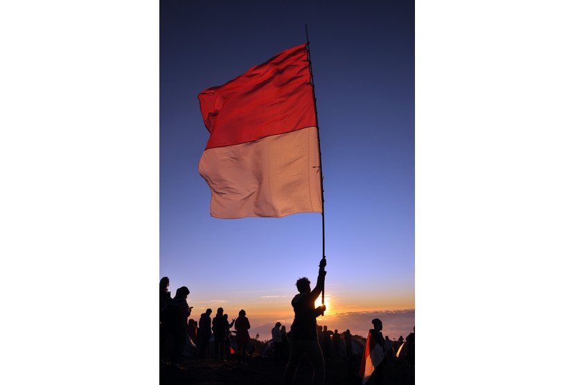 Bendera merah putih berkibar sambil menyanyikan lagu Indonesia Raya (ilustrasi)