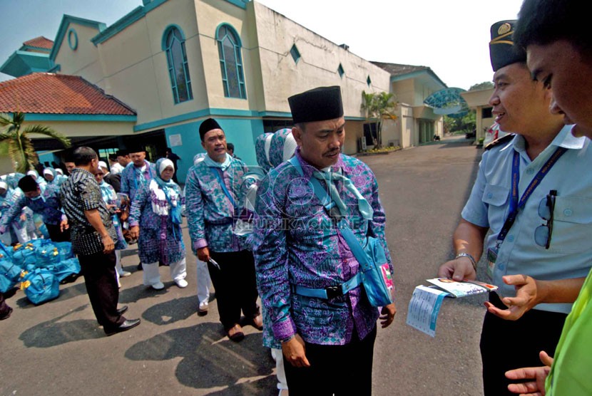    Petugas memeriksa paspor calon jamaah haji sebelum menaiki bus yang akan membawa jamaah menuju Bandara di Pondok Asrama Haji, Pondok Gede, (Ilustrasi)