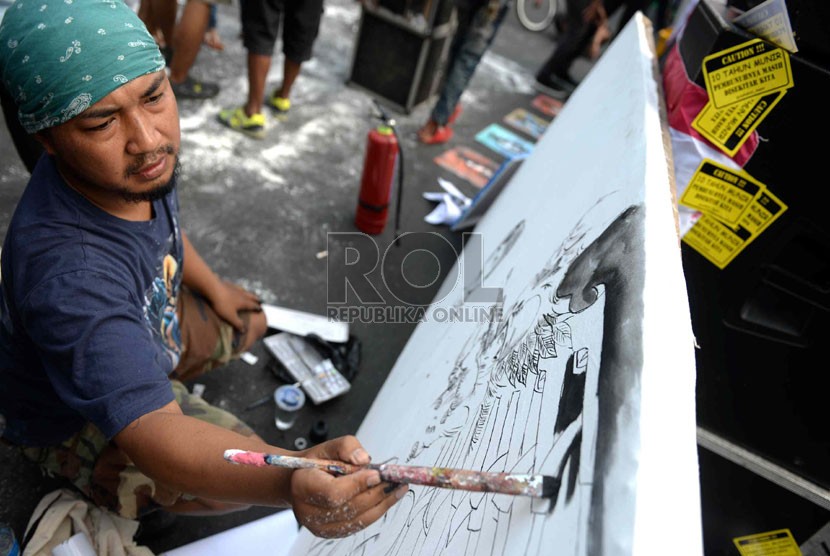 Komite Aksi Solidaritas untuk Munir (Kasum) melukis stensil wajah munir saat peringatan 10 tahun kasus pembunuhan aktivis HAM Munir di Bundaran HI, Jakarta, Ahad (7/9). (Republika/Wihdan)