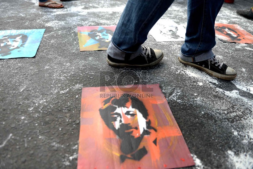  Komite Aksi Solidaritas untuk Munir (Kasum) melukis stensil wajah munir saat peringatan 10 tahun kasus pembunuhan aktivis HAM Munir di Bundaran HI, Jakarta, Ahad (7/9). (Republika/Wihdan)