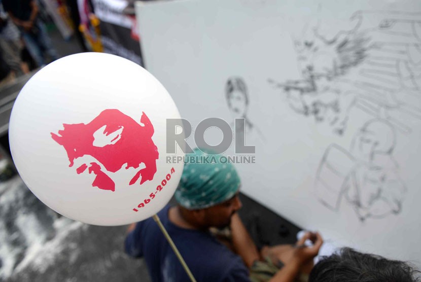  Komite Aksi Solidaritas untuk Munir (Kasum) melukis stensil wajah munir saat peringatan 10 tahun kasus pembunuhan aktivis HAM Munir di Bundaran HI, Jakarta, Ahad (7/9). (Republika/Wihdan)