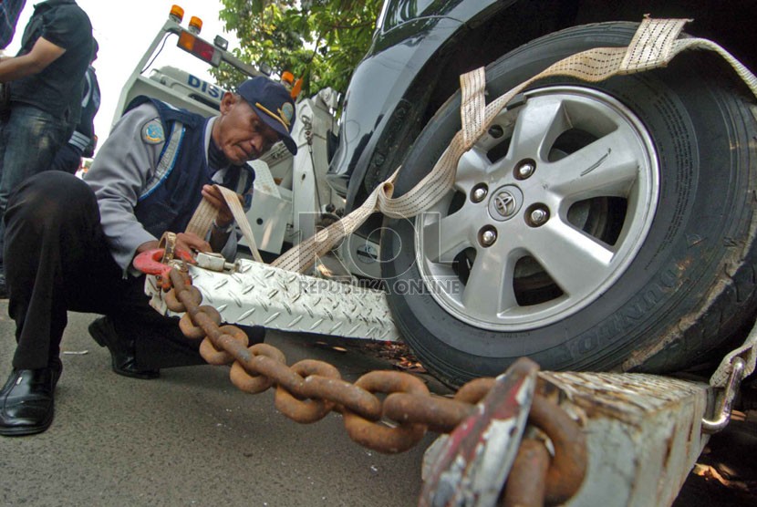  Petugas dari Dinas Perhubungan melakukan penertiban mobil taksi yang parkir sembarangan di kawasan Kalibata, Jakarta Selatan, Senin (8/9). (Republika/Raisan Al Farisi)