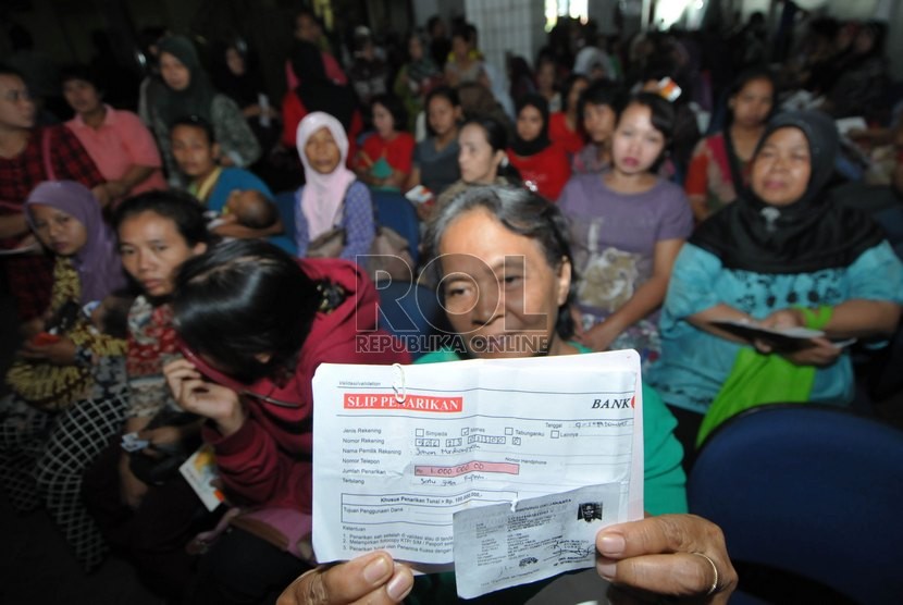  Ratusan orang tua murid mengantre sejak pagi untuk mencairkan dana Kartu Jakarta Pintar (KJP) di kawasan Matraman, Jakarta Timur, Selasa (9/9). ( Republika/Rakhmawaty La'lang )