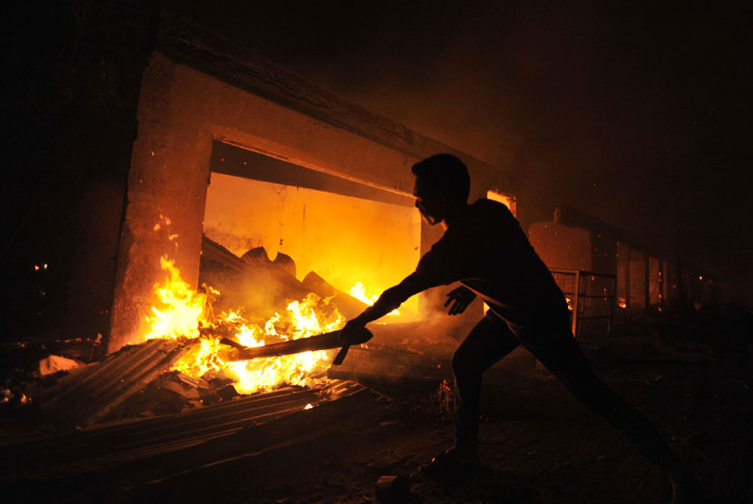 Sejumlah warga berusaha memadamkan api saat terjadi kebakaran pasar Hartaco Makassar, Sulsel, Selasa (16/9) malam.  (Antara/Yusran Uccang)