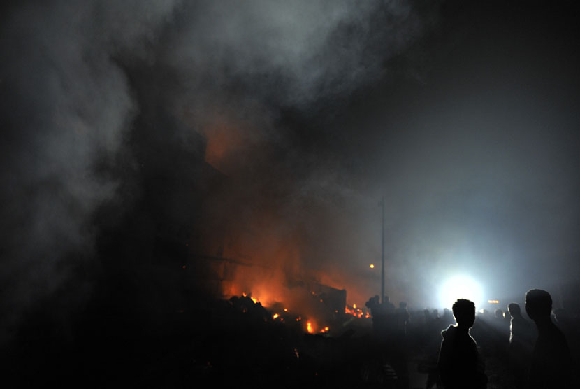 Sejumlah warga berusaha memadamkan api saat terjadi kebakaran pasar Hartaco Makassar, Sulsel, Selasa (16/9) malam.  (Antara/Yusran Uccang)