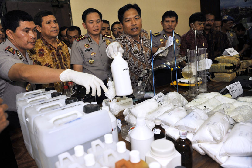 Polisi memeriksa barang bukti berupa zat kimia bahan sabu-sabu atau prekursor dan berbagai alat produksinya saat pengungkapan kasus pabrik sabu-sabu di Mapolresta Denpasar, Bali, Jumat (19/9). (Antara/Nyoman Budhiana)