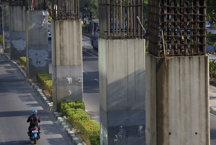 Pengendara melintasi tiang pancang monorel yang mangkrak di Jalan Rasuna Said Jakarta, Jumat (19/9).   (Antara/Wahyu Putro )