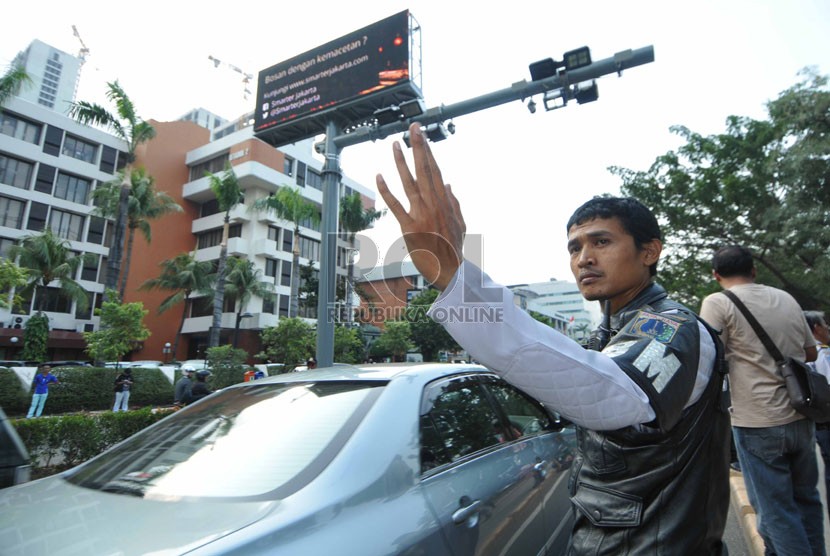  Petugas dinas perhubungan mengatur kendaraan yang melintas saat  uji coba mesin electronic road pricing (ERP) di Jalan H.R. Rasuna Said, Kuningan, Jakarta Selatan, Selasa (30/9). (Republika/Rakhmawaty La'lang)  
