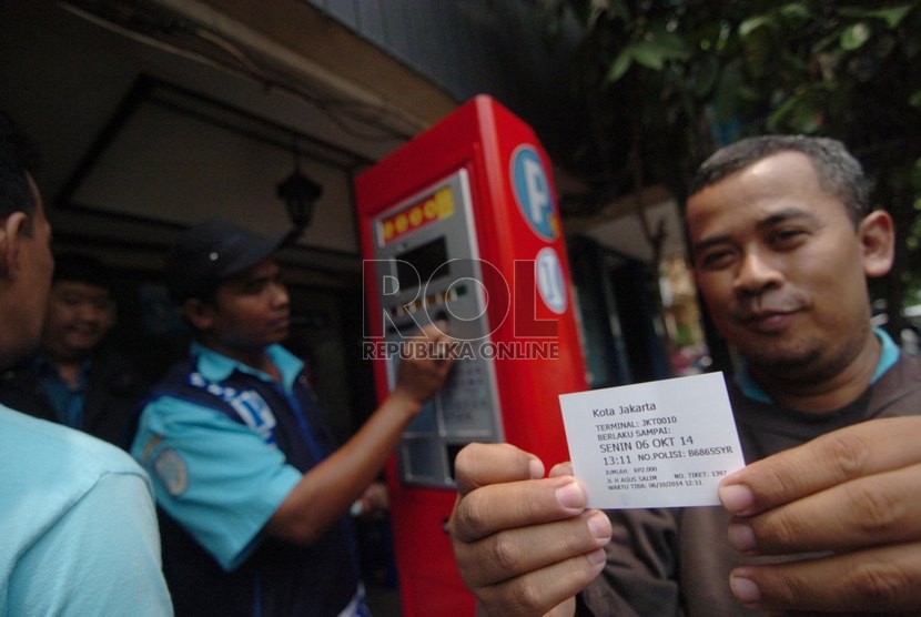   Pengendara menunjukkan tiket karcis parkir setelah melakukan transaksi dalam mesin parkir meter di Jalan Sabang, Jakarta Pusat, Senin (6/10). (Republika/Raisan Al Farisi)