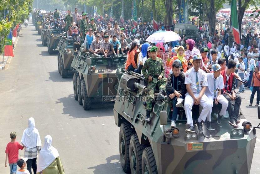   Ratusan warga menaiki kendaraan taktis tempur Anoa milik TNI AD, saat Pameran Alutsista di Makodam V/ Brawijaya Surabaya, Rabu (8/10).   (Republika/Eric Ireng)