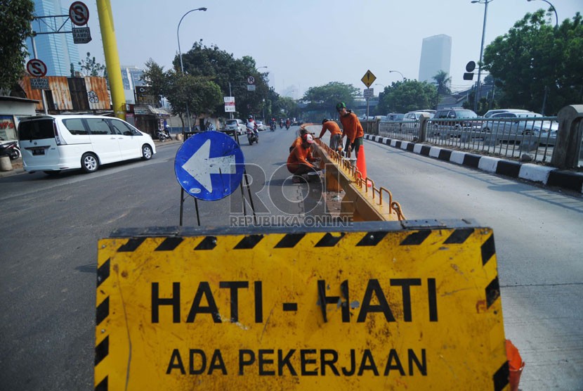   Pekerja dari Suku Dinas Pekerjaan Umum Jakarta Selatan mengecat separator busway di persimpangan Jalan Tendean, Jakarta Selatan, Ahad (12/10). (Republika/Raisan Al Farisi)
