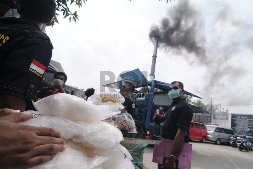 Asap hitam mengepul dari mesin pemusnah barang bukti shabu sebanyak 71,5 kg yang telah disita di lapangan parkir Gedung  BNN, Jakarta Timur, Selasa (14/10). (Republika/Raisan Al Farisi)