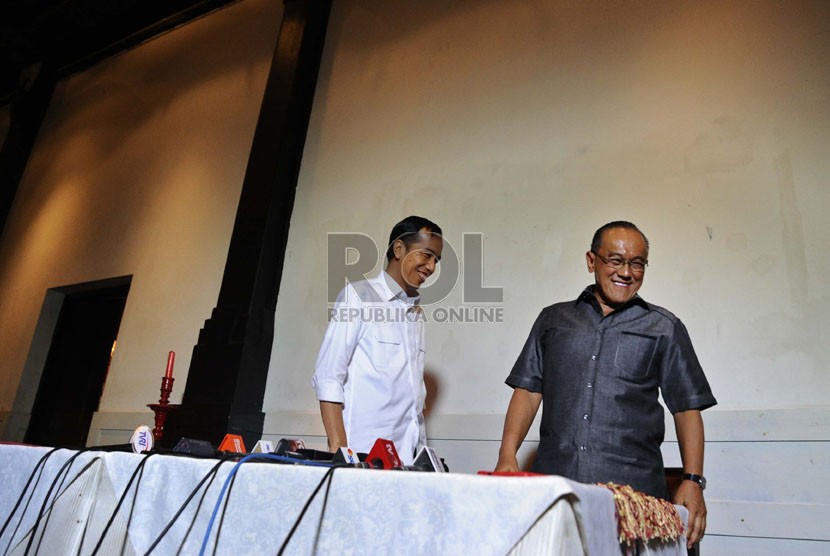  Presiden terpilih Joko Widodo (kiri) bersama Ketua Umum Partai Golkar Aburizal Bakrie (kanan) berjalan usai melakukan pertemuan tertutup di Jakarta, Selasa (14/10). (Republika/ Tahta Aidilla)