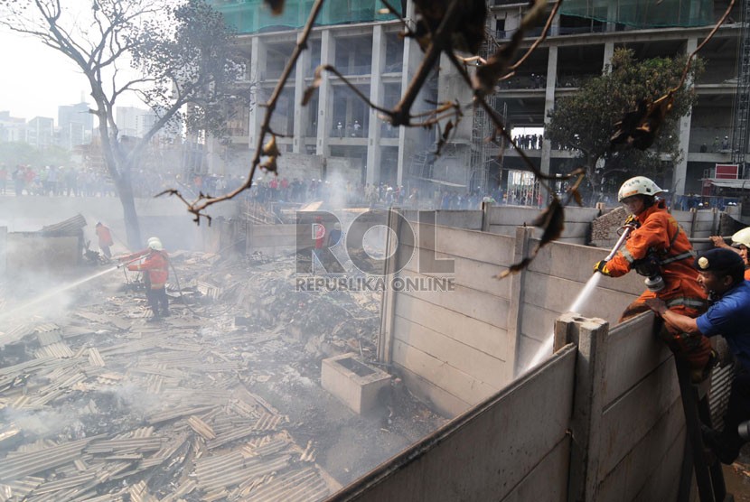    Petugas pemadam kebakaran berusaha memadamkan api yang melahap mess pekerja di Gang Jangkrik, Jalan Guru Mukni, Semanggi, Jakarta Selatan, Selasa (14/10). (Republika/Raisan Al Farisi)