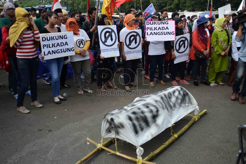  Aksi unjuk rasa menuntut pilkada langsung di depan Gedung DPR, Senayan, Jakarta, Selasa (14/10).(Republika/Agung Supriyanto)