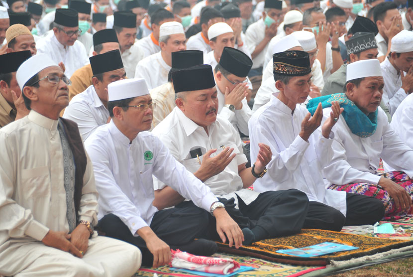   Gubernur Sumatera Selatan Alex Noerdin (tengah), khusuk berdoa usai shalat Istisqo berjamaah memohon hujan turun, di Lapangan Kantor Pemerintah Provinsi Sumsel, Selasa (14/10). (Antara/Feny Selly)