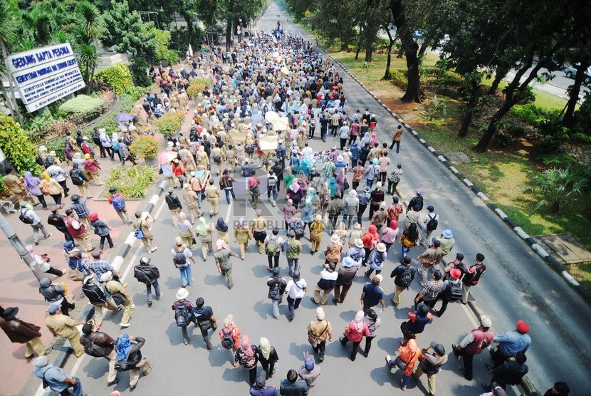   Ribuan tenaga honorer dari berbagai perwakilan daerah melakukan aksi demo dengan berjalan kaki dari Patung Arjuna menuju Istana, Jakarta Pusat, Rabu (15/10).  ( Republika/Raisan Al Farisi)