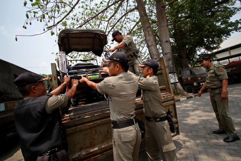  Petugas Satpol PP menurunkan becak dari truk di Kantor Satpol PP Kota Semarang, Jawa Tengah, Rabu (15/10).  (Antara/Noveradika)