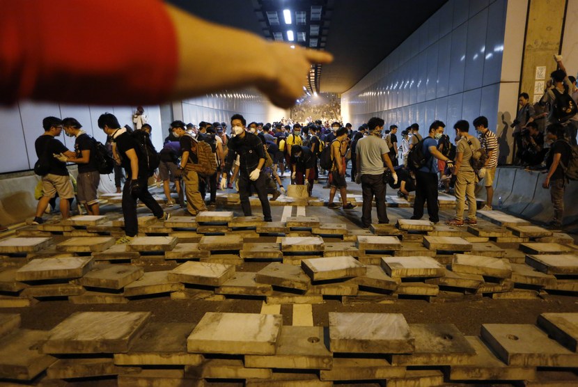  Demonstran pro-demokrasi membuat barikade dari blok semen di sebuah terowongan di Jalan Lung Wo, Distrik Admiralty, Hong kong, Rabu (15/10). (AP/Kin Cheung)