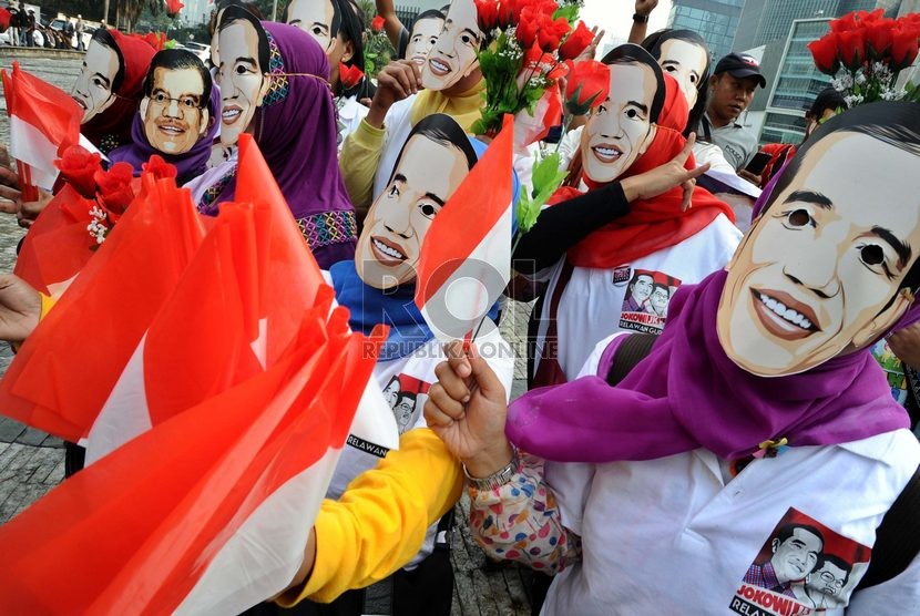  Massa relawan Jokowi menggunakan topeng dalam aksi menyambut pelantikan presiden terpilih Jokowi di Bundaran HI, Jakarta, Rabu (15/10).   (Republika/ Tahta Aidilla)