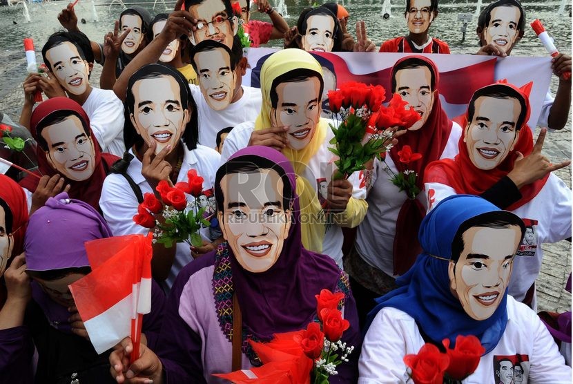  Massa relawan Jokowi menggunakan topeng dalam aksi menyambut pelantikan presiden terpilih Jokowi di Bundaran HI, Jakarta, Rabu (15/10).   (Republika/ Tahta Aidilla)