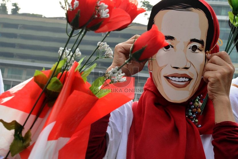  Massa relawan Jokowi menggunakan topeng dalam aksi menyambut pelantikan presiden terpilih Jokowi di Bundaran HI, Jakarta, Rabu (15/10).   (Republika/ Tahta Aidilla)