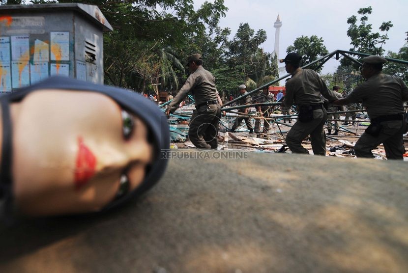  Sejumlah petugas Satpol PP menertibkan kios yang menjadi lapak Pedagang Kaki Lima (PKL) di IRTI Monas, Jakarta Pusat, Kamis (16/10).   (Republika/Raisan Al Farisi)