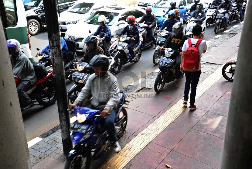  Pengendara roda dua melintasi jalur khusus bagi pejalan kaki di jalan Sudirman, Jakarta Pusat, Kamis (16/10).  (Republika/ Tahta Aidilla) 