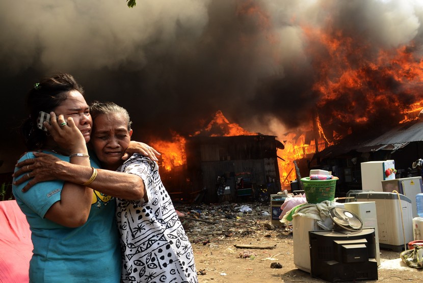  Warga korban kebakaran menelpon kerabatnya saat terjadi kebakaran rumah warga di Kecamatan Rappocini Makassar, Sulsel, Kamis (23/10).    (Antara/Yusran Uccang)