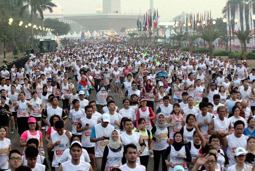 Peserta Jakarta Marathon berlari di kawasan Monumen Nasional, Jakarta, Ahad (26/10).  (Republika/ Yasin Habibi)