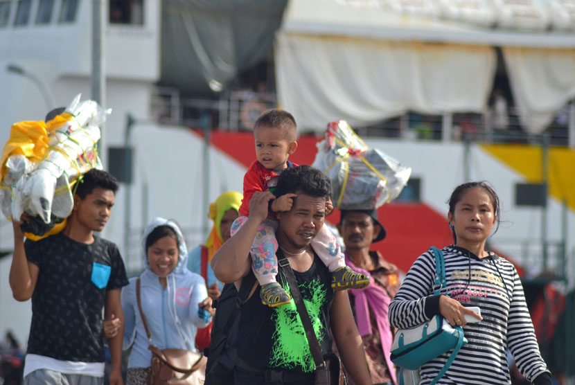  Calon tenaga kerja Indonesia (CTKI) memanggul anaknya yang masih balita didampingi istrinya saat tiba di Pelabuhan Tunon Taka Kabupaten Nunukan, Kalimantan Utara, Senin (27/10). (Antara/M Rusman)