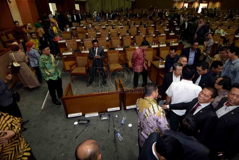  Sejumlah anggota dewan menyaksikan meja Ketua Fraksi PPP Hasrul Azwar yang terbalik saat rapat paripurna terkait pengesahan alat kelengkapan dewan (AKD) di Gedung Nusantara II, DPR, Jakarta, Selasa (28/10). (Republika/Agung Supriyanto)