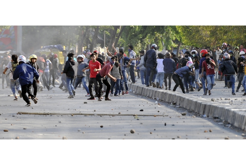   Sejumlah mahasiswa melempari polisi saat terjadi bentrokan antara mahasiswa dan polisi di depan kampus Universitas Negeri Makassar (UNM), Makassar, Sulsel, Selasa (28/10).  (Antara/Yusran Uccang)