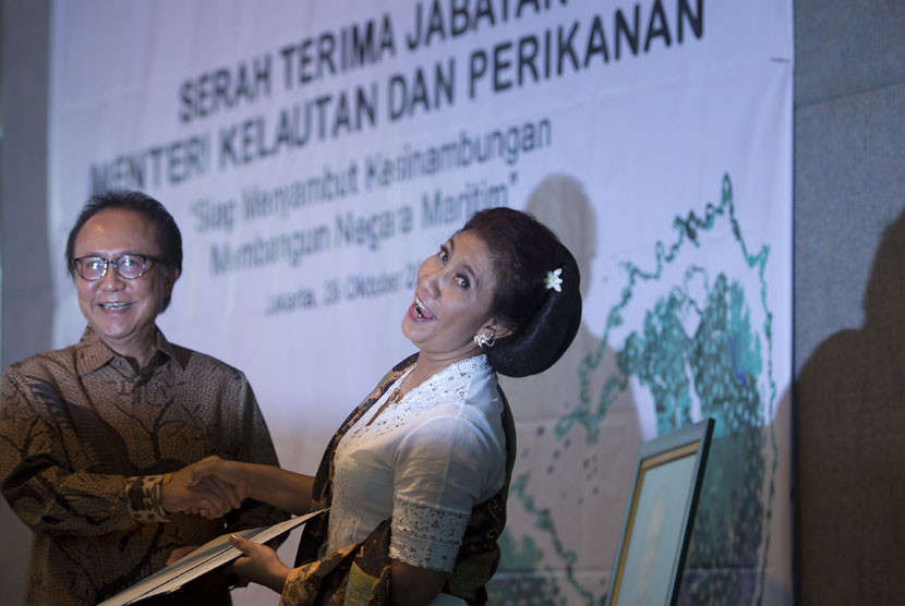 Menteri Kelautan dan Perikanan baru Susi Pudjiastuti (kanan) berjabat tangan dengan Menteri Kelautan dan Perikanan sebelumnya Sharif Cicip Sutardjo (kiri) dalam serah terima jabatan menteri kelautan dan perikanan di Kantor Kementerian KKP, Jakarta, Rabu (2
