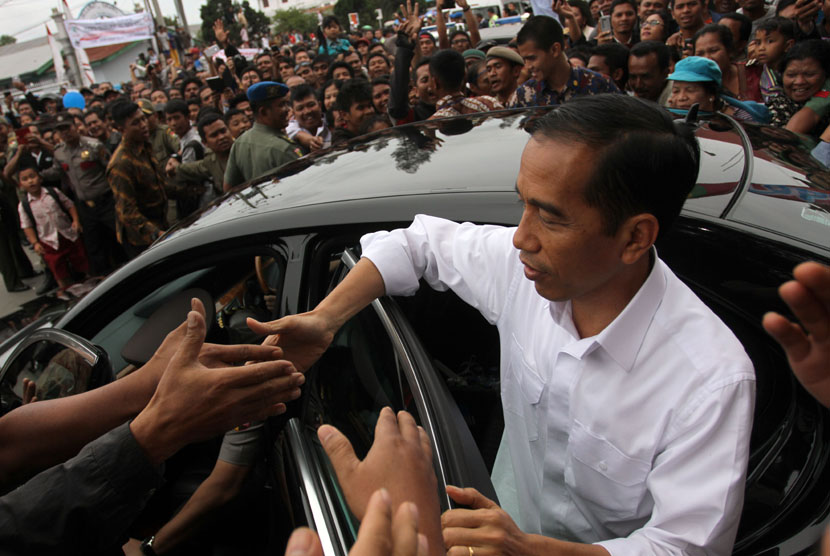Presiden Joko Widodo menyalami warga ketika akan mengunjungi pengungsi erupsi Gunung Sinabung, Karo, Sumut, Rabu (29/10).  (Antara/Irsan Mulyadi)