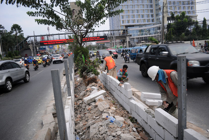 Pekerja menyelesaikan pembuatan pelebaran taman separator di Jalan Margonda Raya, Depok, Jawa Barat, Jum'at (31/10).  (Antara/Indrianto Eko Suwarso)