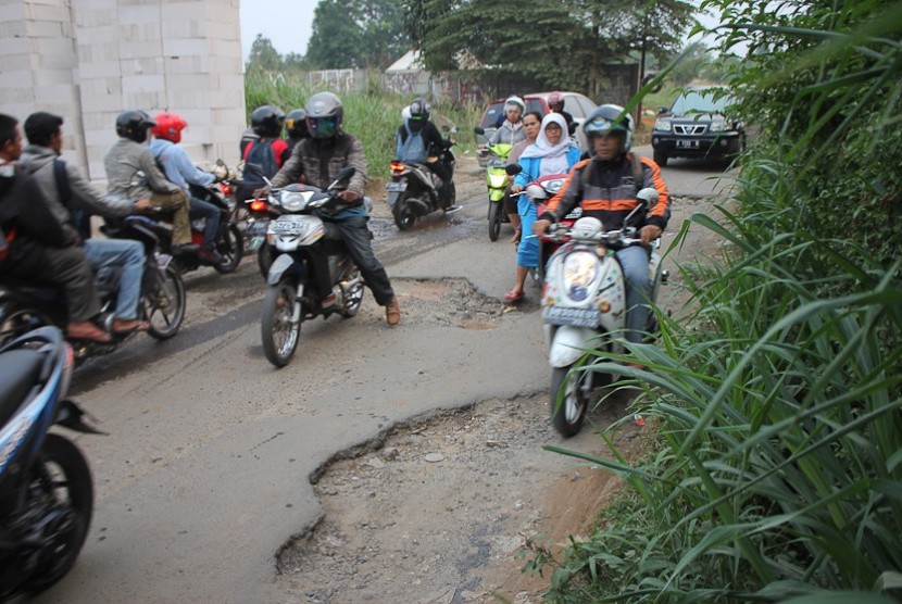  Jalan rusak dan berlubang di Jalan Raya Pengasinan Sawangan Depok, Ahad (2/11).  (foto: MgROL30 )