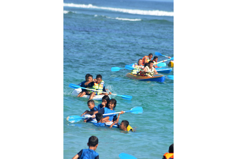   Wisatawan bermain kano di Pantai Pandawa, Kab. Badung, Bali, Ahad (2/11). (Antara/Fikri Yusuf)