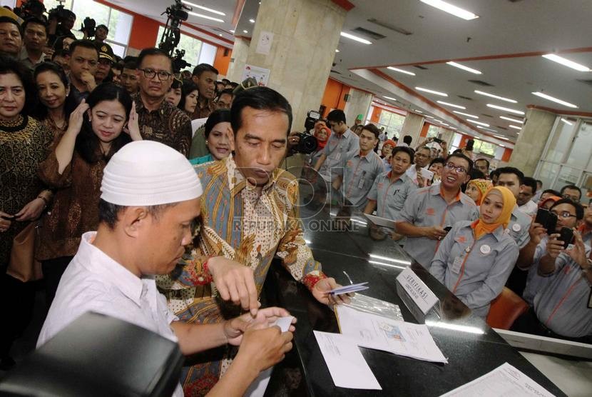  Presiden Joko Widodo memberi Kartu Indonesia Sehat (KIS), Kartu Indonesia Pintar (KIP) dan Kartu Keluarga Sejahtera (KKS) secara simbolis pada warga yang berhak di Kantor Pos Besar, Jakarta Pusat, Senin (3/11). (Republika/ Yasin Habibi)