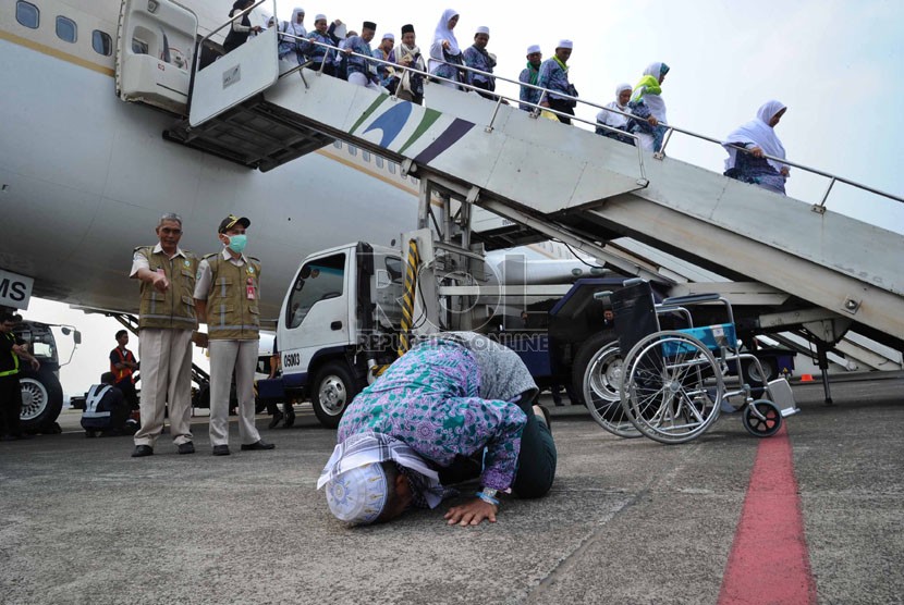Jamaah haji melakukan sujud syukur saat tiba di Bandara Halim Perdana Kusuma, Jakarta, Rabu (5/11). (Republika/Tahta Aidilla)