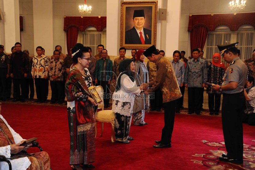  Presiden Jokowi memberikan ucapan selamat kepada 4 pejuang  penerima gelar Pahlawan Nasional  di Istana Merdeka, Jakarta, Jumat (7/11). (Republika/Tahta Aidilla)