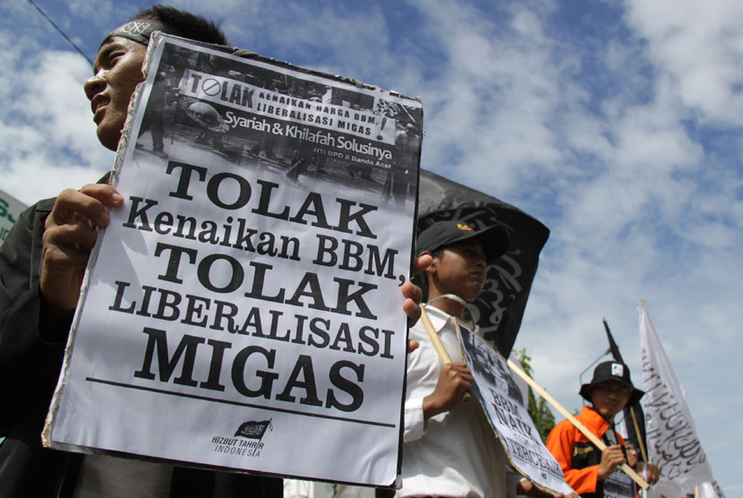  Aktivis yang tergabung dalam Hizbut Tahrir Indonesia (HTI) mengusung spanduk dan poster berjalan kaki menuju kantor DPRA saat aksi menolak liberalisasi migas dan kenaikan bahan bakar minyak di Banda Aceh, Jumat (7/11). (Antara/Ampelsa)