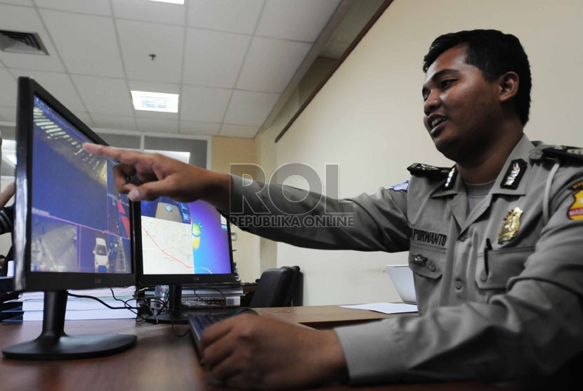   Petugas operator melakukan pemantauan lewat monitor CCTV saat uji coba pemberlakukan tilang elktronik di kantor National Traffic Management Centre (NTMC), Jakarta, Ahad (9/11).(Republika/Rakhmawaty La'lang )