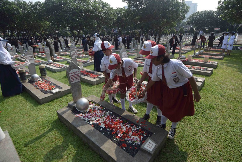    Sejumlah siswa melakukan tabur bunga ke sejumlah makam pahlawan usai Upacara Ziarah Nasional di Taman Makam Pahlawan Nasional, Kalibata, Jakarta, Senin (10/11). (Republika/Agung Supriyanto)