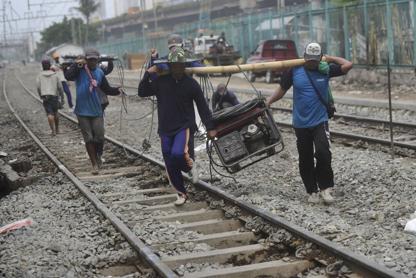  Pekerja membawa alat yang digunakan untuk memperbaiki rel kereta api di Kawasan Pademangan, Jakarta Utara, Selasa (11/11). (Antara/Wahyu Putro A)